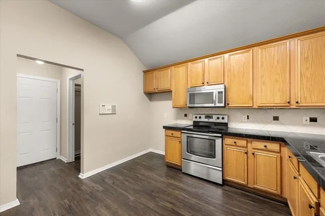 a kitchen with wooden floors and stainless steel appliances