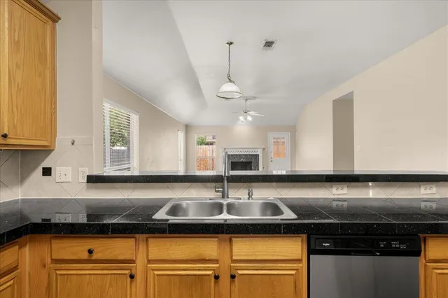 a kitchen with granite countertop a sink stainless steel appliances and cabinets