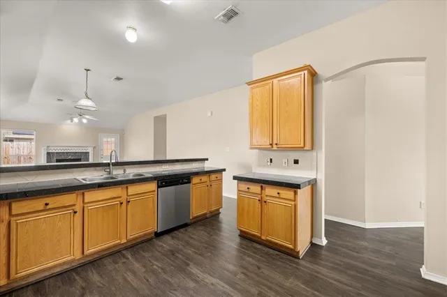 a kitchen with granite countertop a sink cabinets and wooden floor