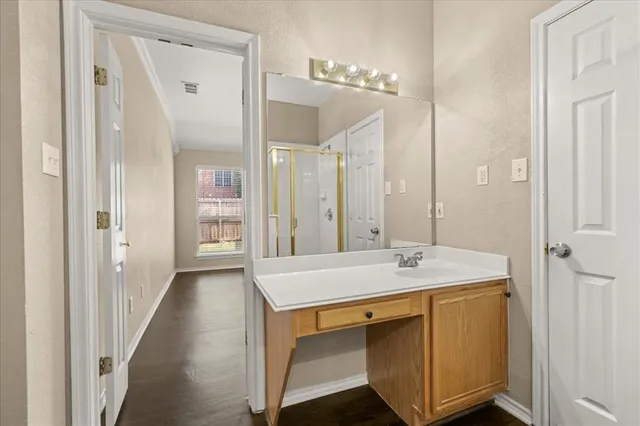 a spacious bathroom with a granite countertop sink a mirror and a shower