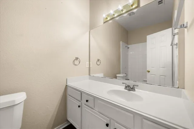 a bathroom with a sink a toilet and a mirror