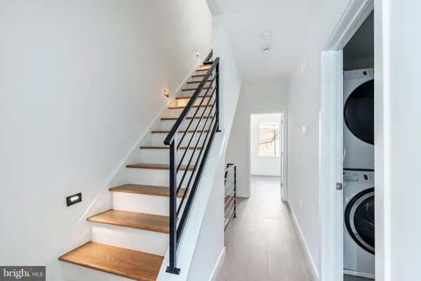 a view of a hallway with wooden floor and entryway