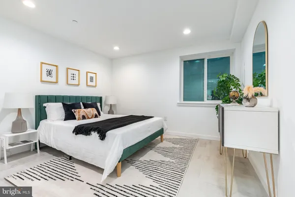 a bedroom with a large bed and a potted plant
