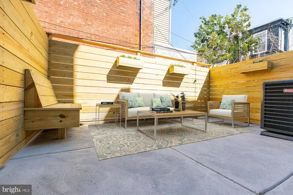 a backyard of a house with barbeque oven table and chairs