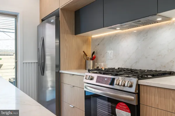 a kitchen with stainless steel appliances granite countertop a refrigerator and a stove