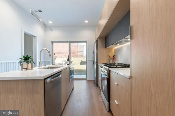 a kitchen with stainless steel appliances granite countertop a sink stove and refrigerator