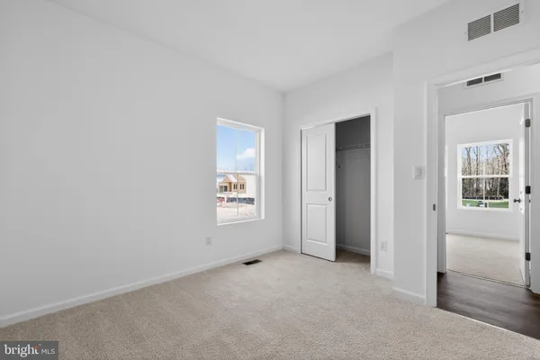 an empty room with windows and closet