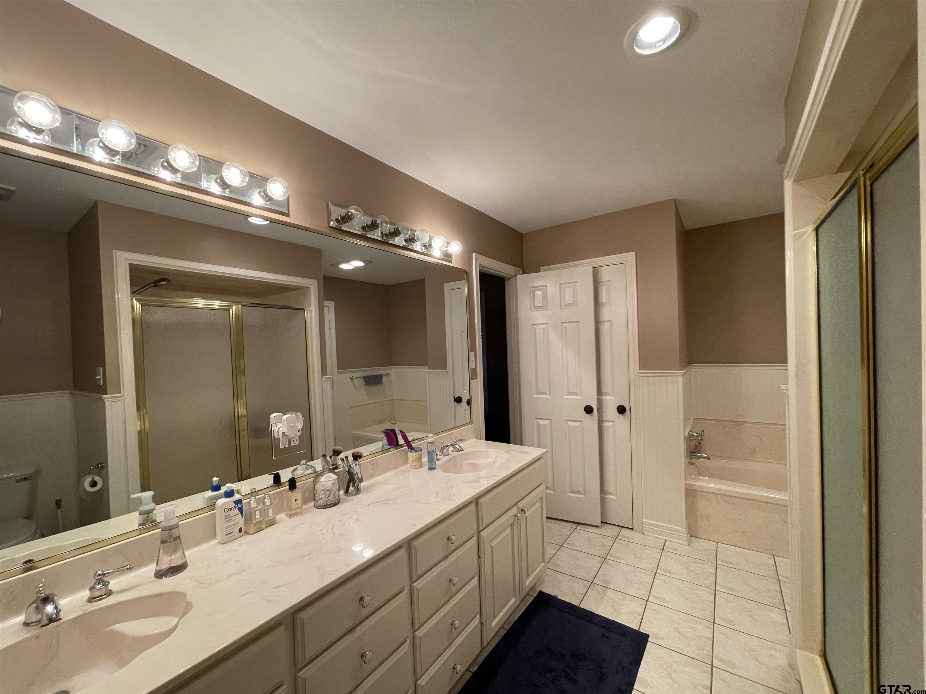 3617 Flagstone Drive Tyler, TX 75707 - Photo 12 of 45 a bathroom with a double vanity sink and a mirror