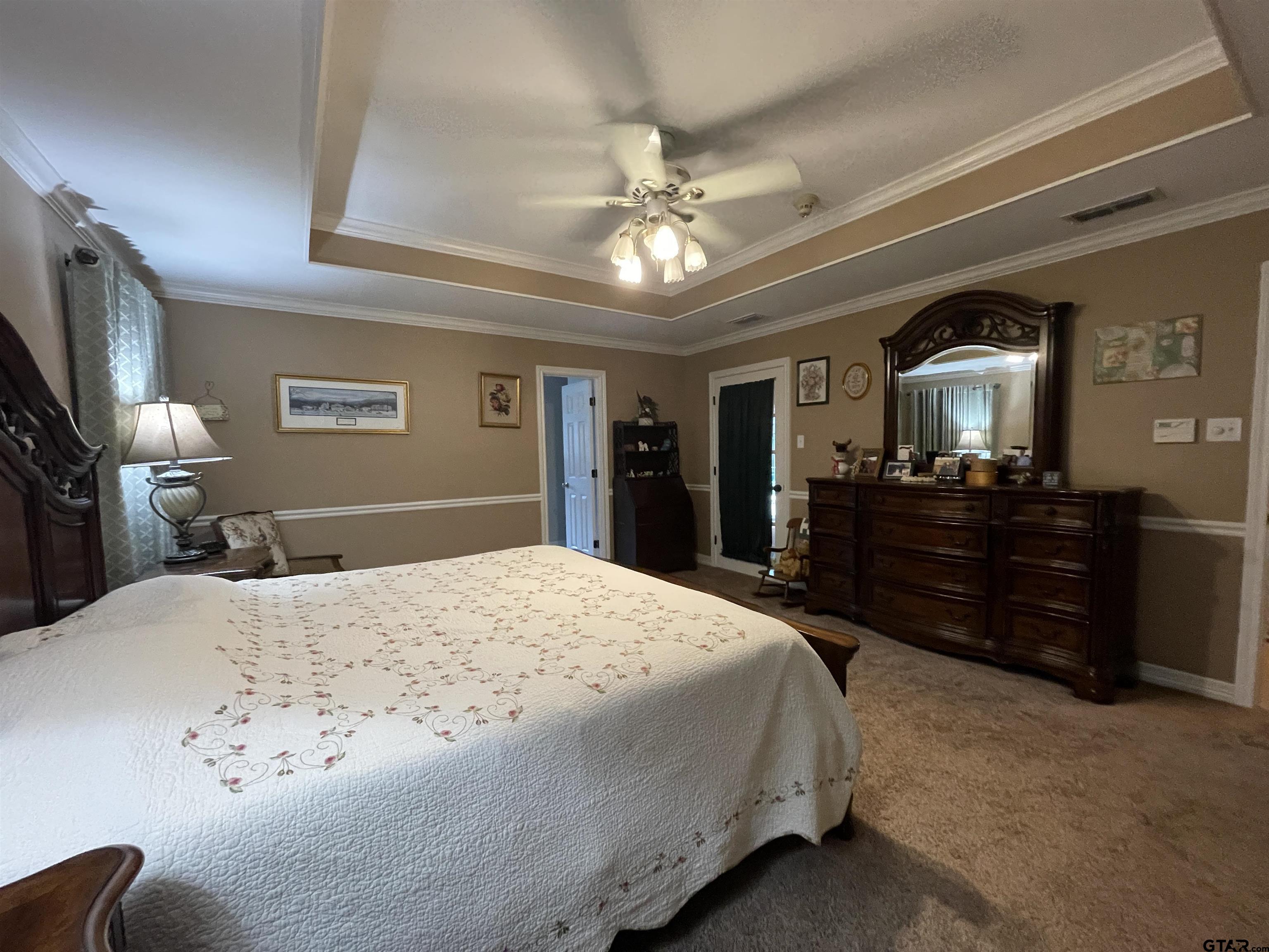 3617 Flagstone Drive Tyler, TX 75707 - Photo 34 of 45 a bedroom with a large bed and a chandelier
