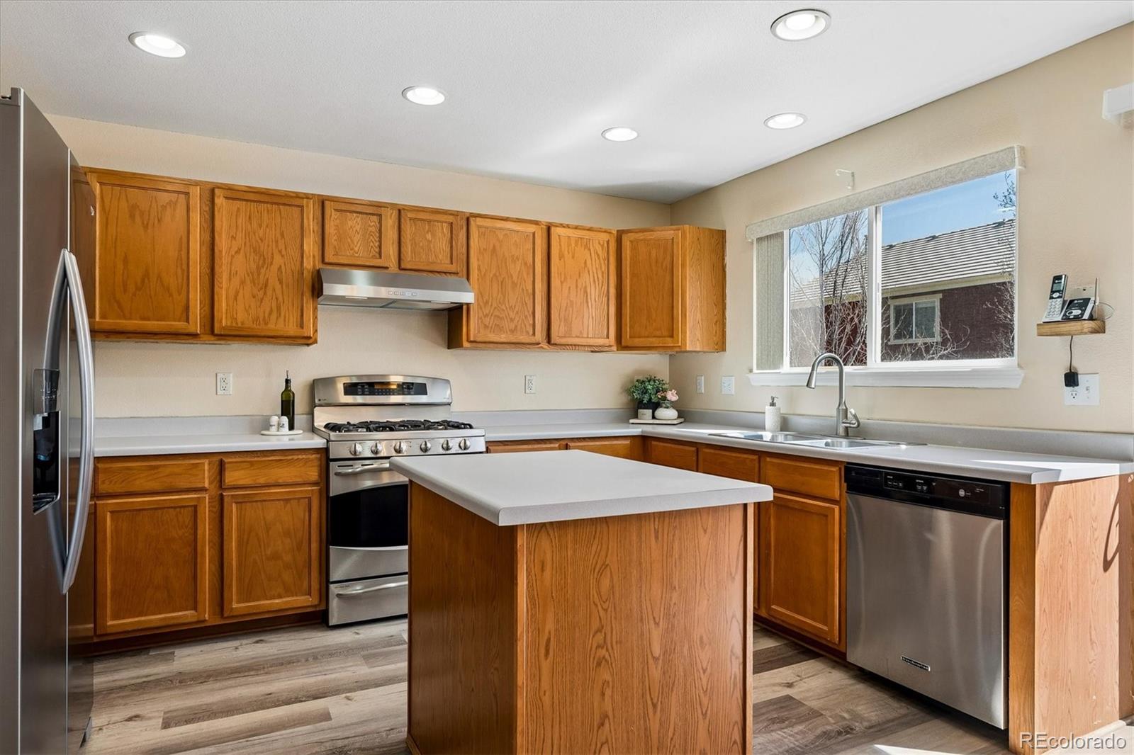 10534 Westcliff Place Highlands Ranch, CO 80130 - Photo 14 of 38 a kitchen with stainless steel appliances granite countertop a sink stove and refrigerator