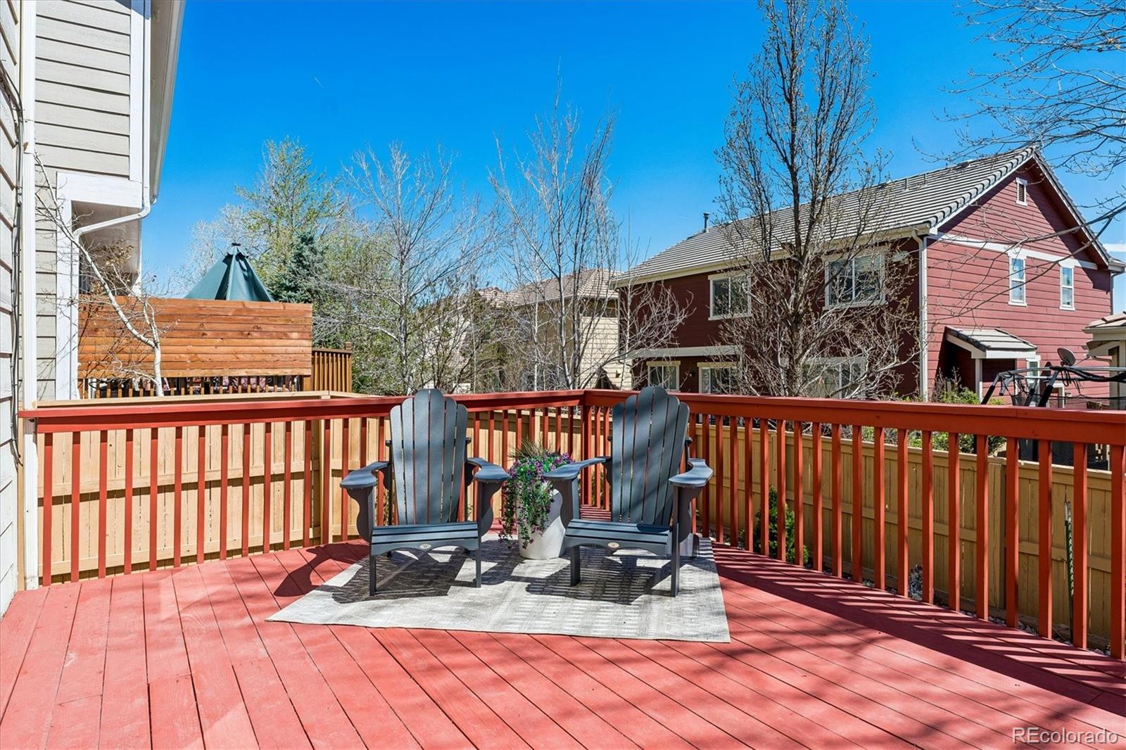 10534 Westcliff Place Highlands Ranch, CO 80130 - Photo 31 of 38 a view of a brick house with large trees and wooden fence