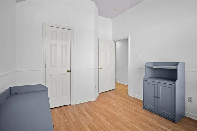 a view of empty room with wooden floor and cabinet