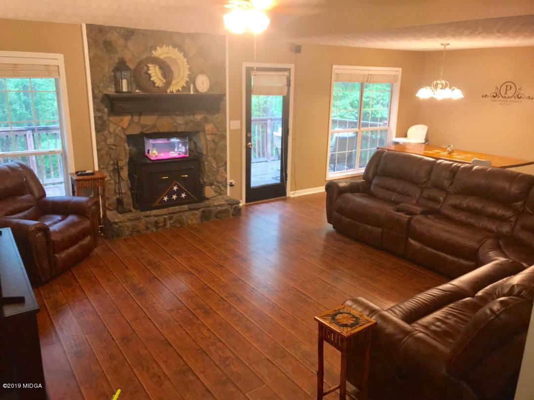 385 Ham Road Jackson, GA 30233 - Photo 22 of 31 a living room with furniture a flat screen tv and a fireplace