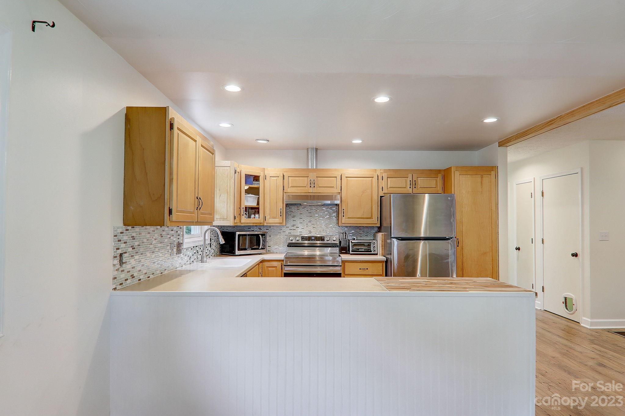 4155 Turnpike Road Horse Shoe, NC 28742 - Photo 12 of 41 a view of kitchen with kitchen island a refrigerator a sink a stove and a refrigerator with wooden floor