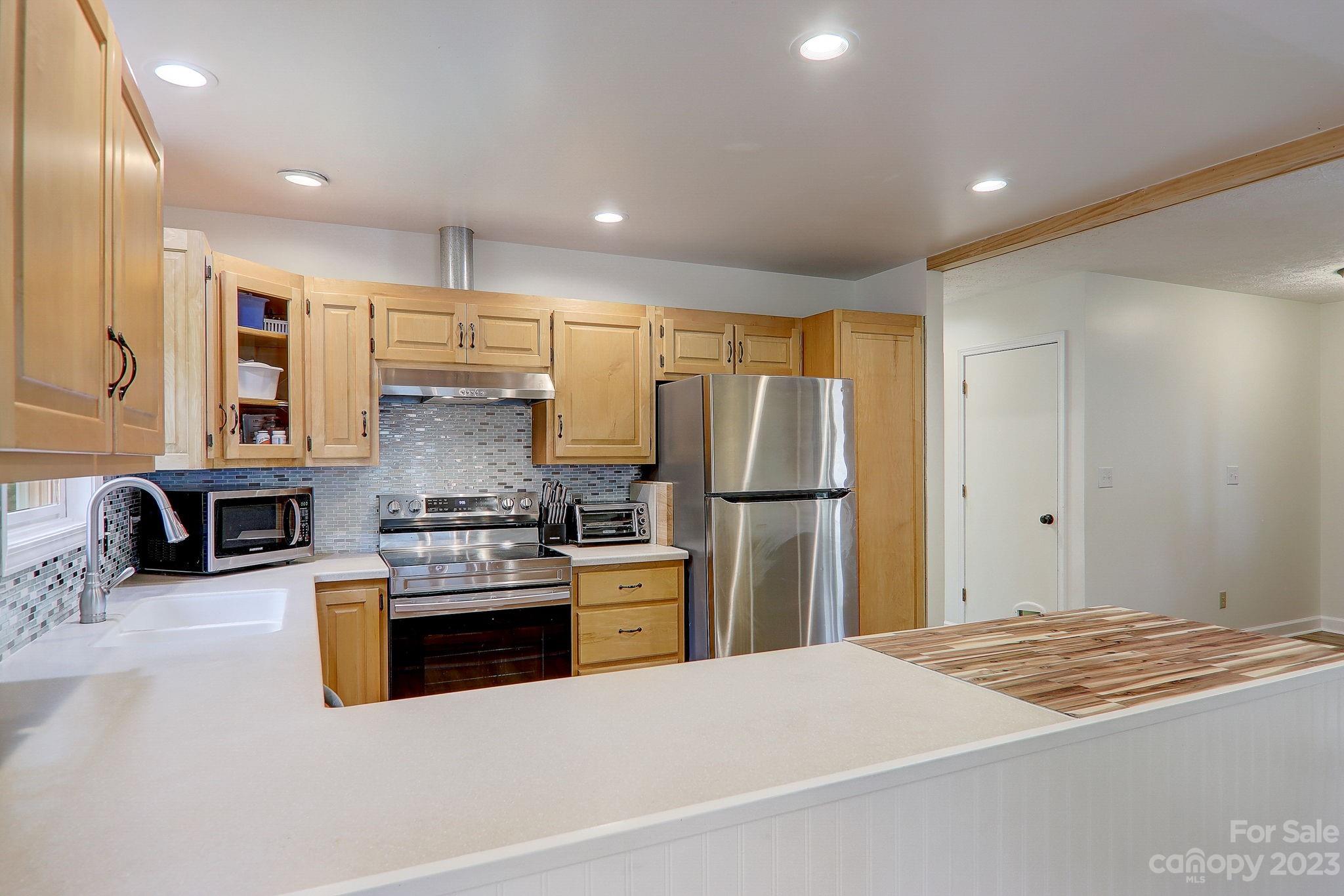 4155 Turnpike Road Horse Shoe, NC 28742 - Photo 15 of 41 a kitchen with stainless steel appliances kitchen island granite countertop a refrigerator and stove