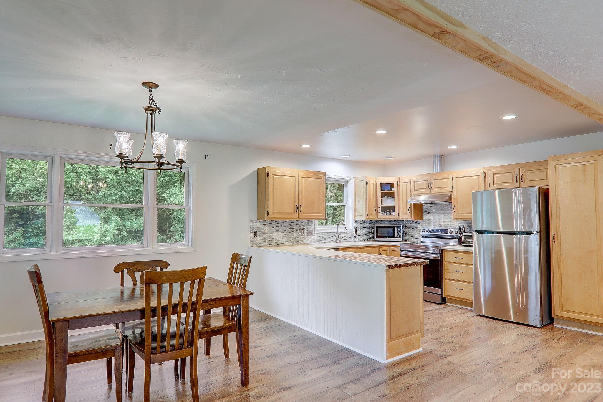 4155 Turnpike Road Horse Shoe, NC 28742 - Photo 10 of 41 a kitchen with refrigerator a stove and chairs