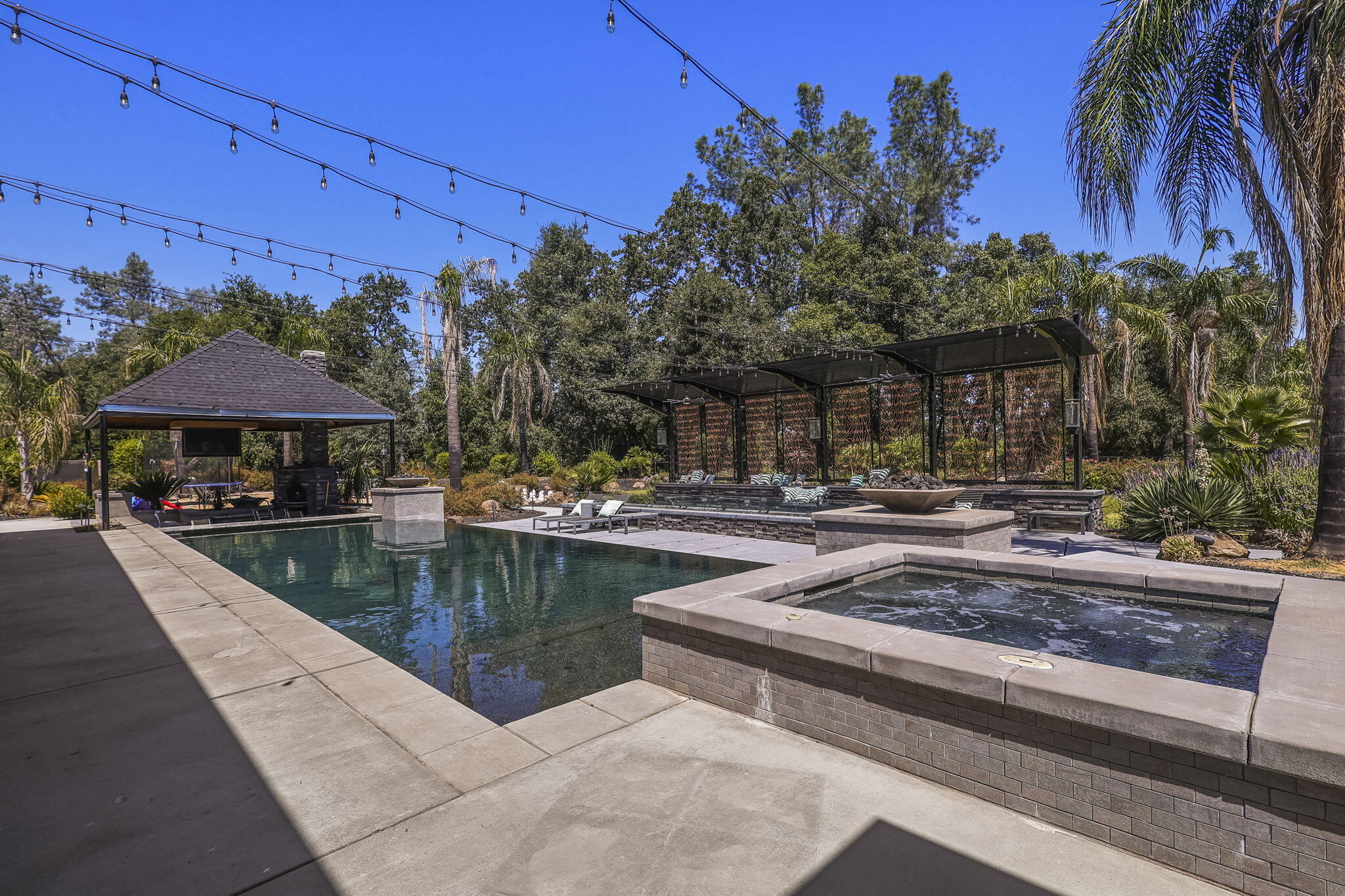 19580 Mockingbird Lane Redding, CA 96002 - Photo 32 of 72 a view of a swimming pool with a table and chairs under an umbrella