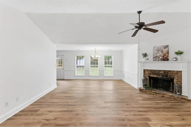 a view of empty room with wooden floor and fireplace