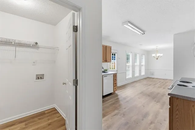 a view of a kitchen with refrigerator and wooden floor
