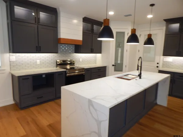 a kitchen with stainless steel appliances kitchen island a sink and a refrigerator