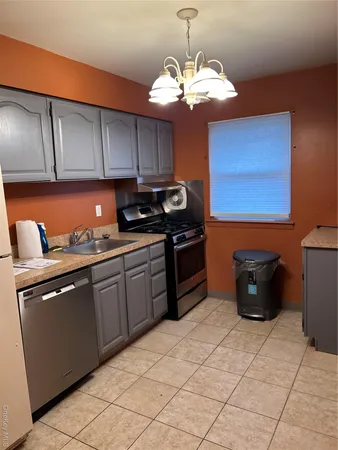 a kitchen with stainless steel appliances granite countertop a sink counter space cabinets and a lamp