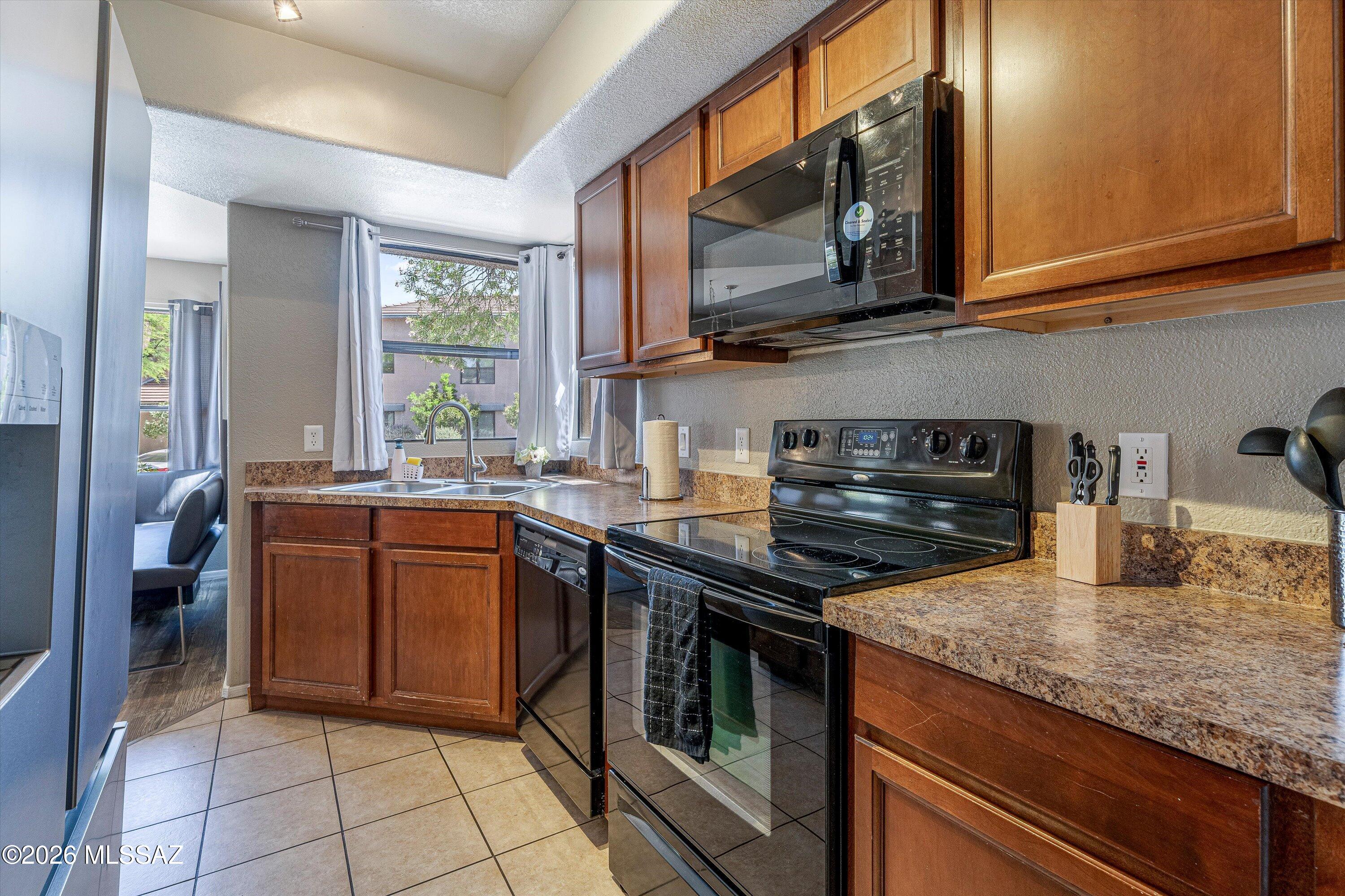 5855 North Kolb Road, Unit 8106 Tucson, AZ 85750 - Photo 6 of 34 a kitchen with stainless steel appliances granite countertop a stove microwave and sink