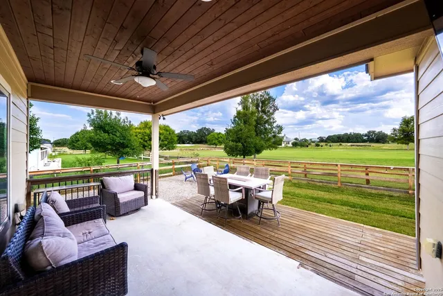 a view of a patio with lawn chairs next to a yard