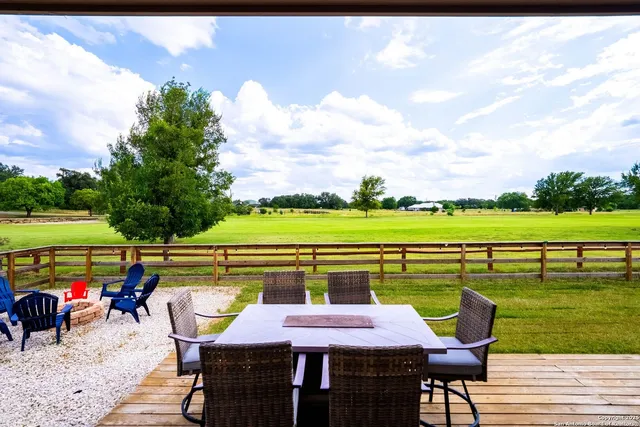 a front view of a house with swimming pool table and chairs