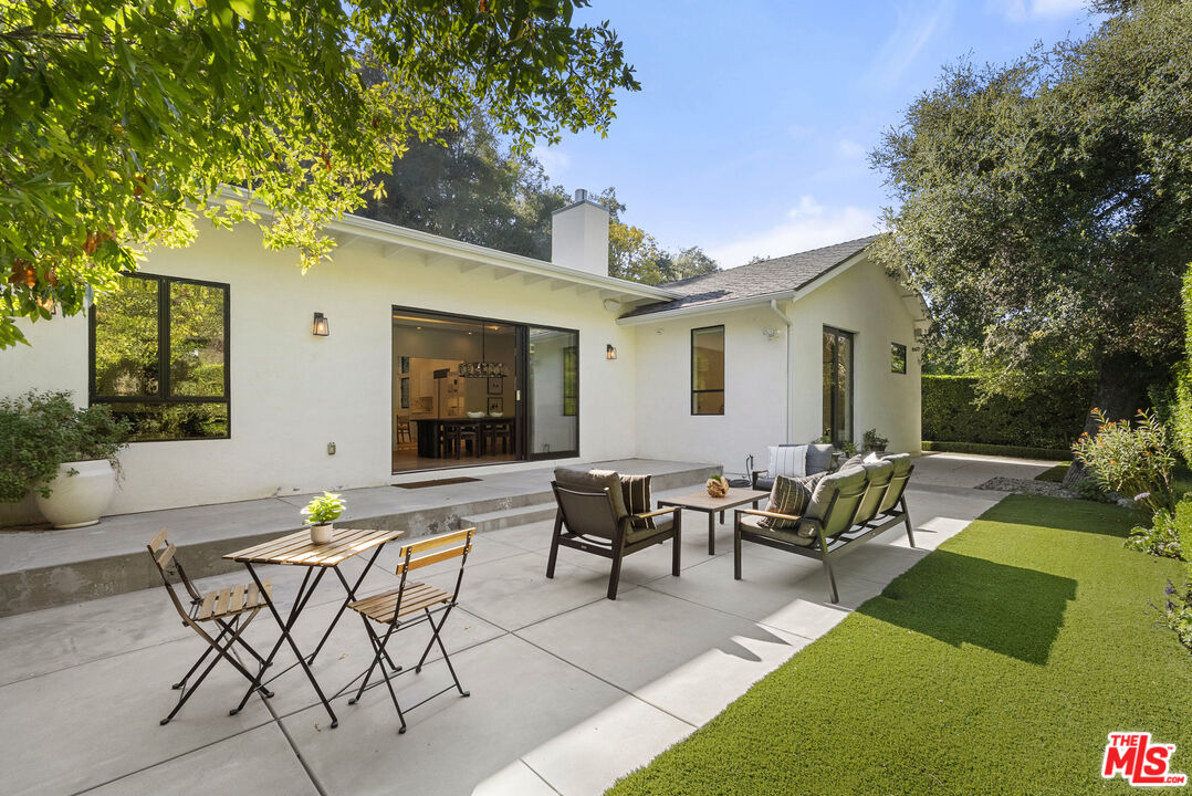 9782 Oak Pass Road Beverly Hills, CA 90210 - Photo 2 of 27 a view of a patio with couches table and chairs and potted plants with large tree