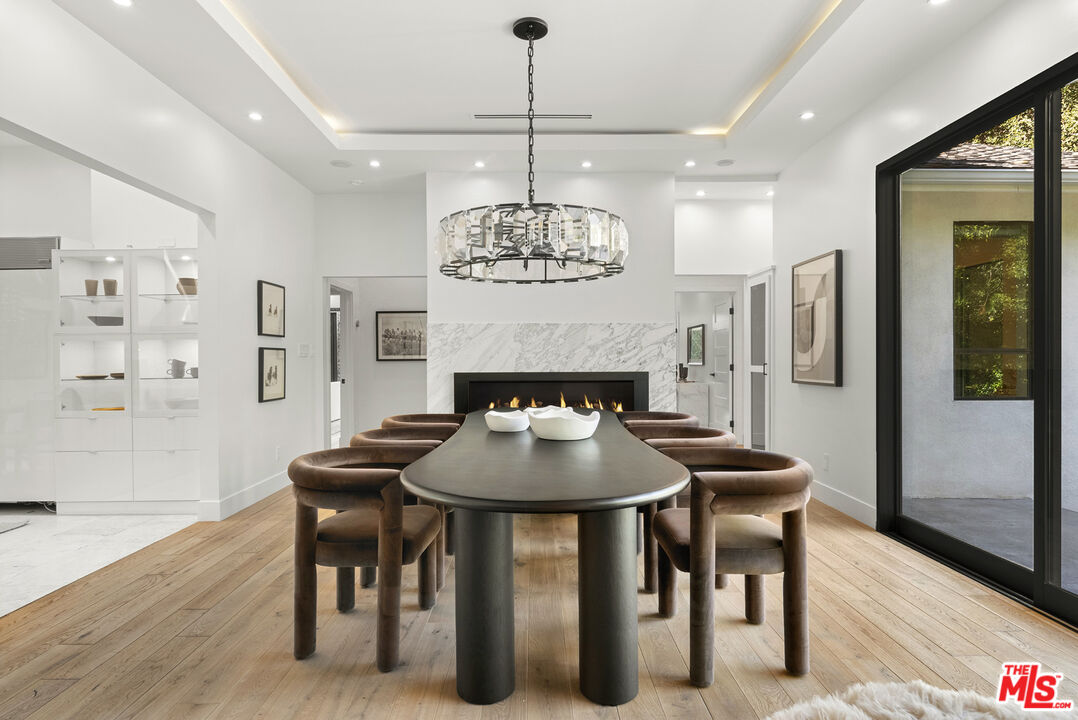 9782 Oak Pass Road Beverly Hills, CA 90210 - Photo 7 of 27 a dining room with furniture a chandelier and wooden floor