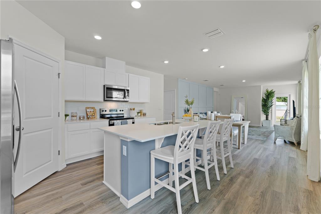 3390 Ft Mellon Lane Sanford, FL 32773 - Photo 4 of 24 a kitchen with stainless steel appliances a table chairs refrigerator and microwave