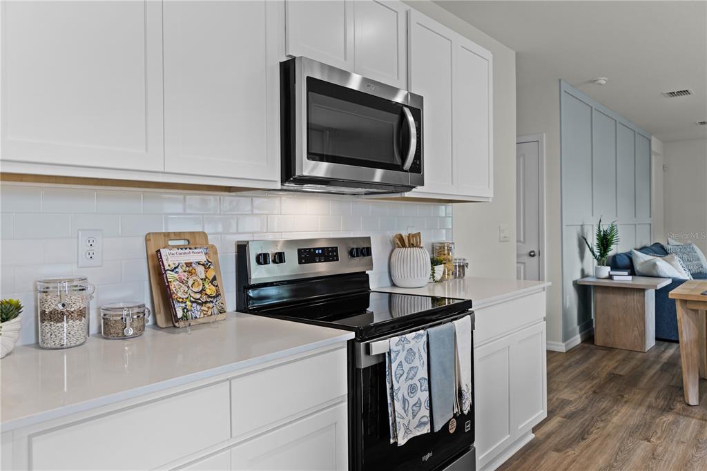 3390 Ft Mellon Lane Sanford, FL 32773 - Photo 5 of 24 a kitchen with a microwave a stove and cabinets