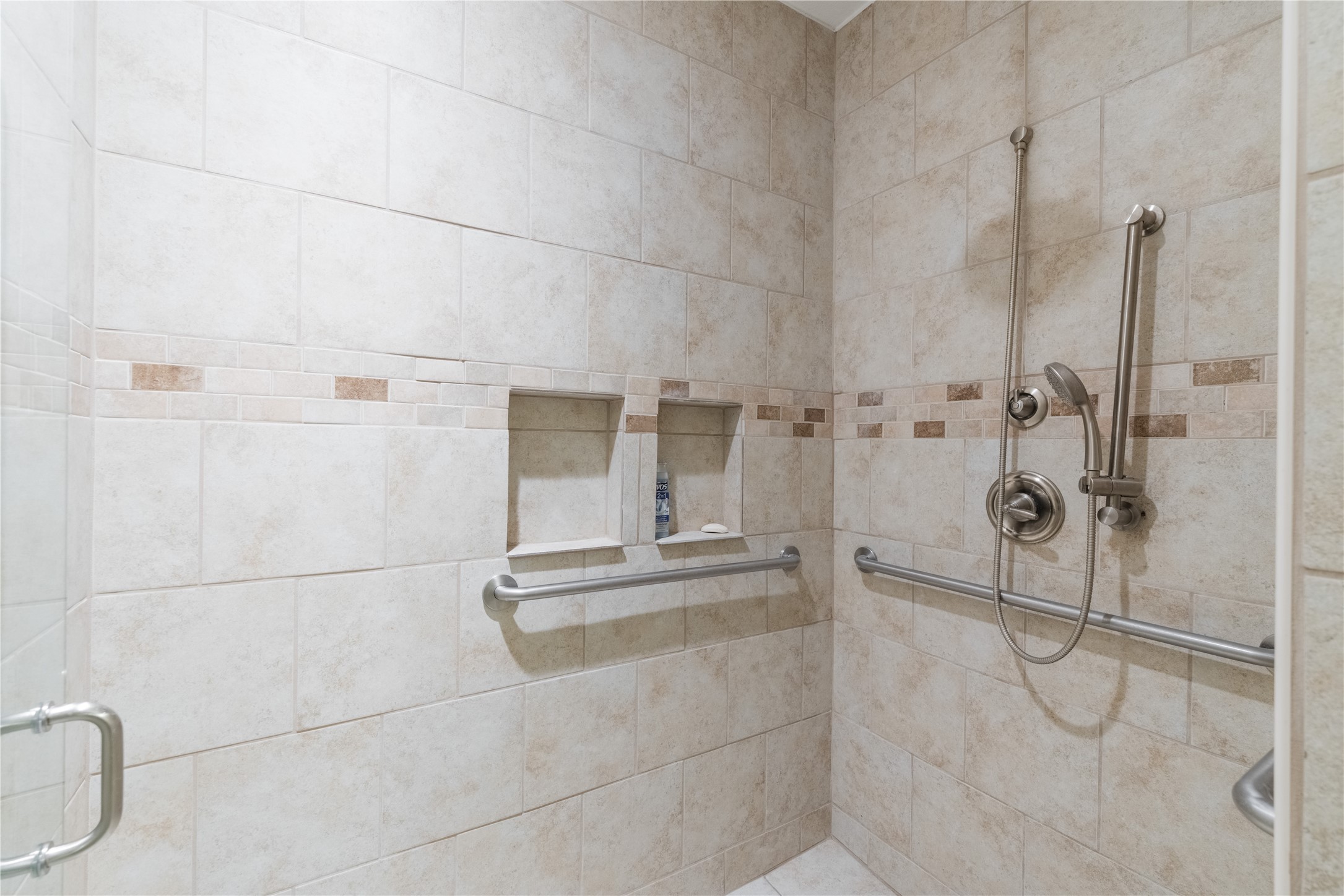 20145 Janak Road Coupland, TX 78615 - Photo 28 of 40 In the garage, there is this accessible shower with decorative tile work and convenient built-in niches for storage.