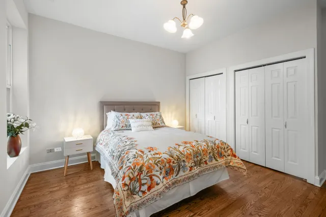 a bedroom with a large bed and a chandelier