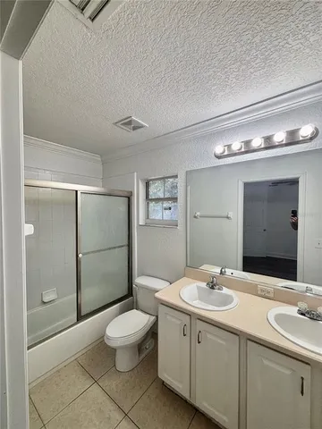 a bathroom with a double vanity sink toilet and shower