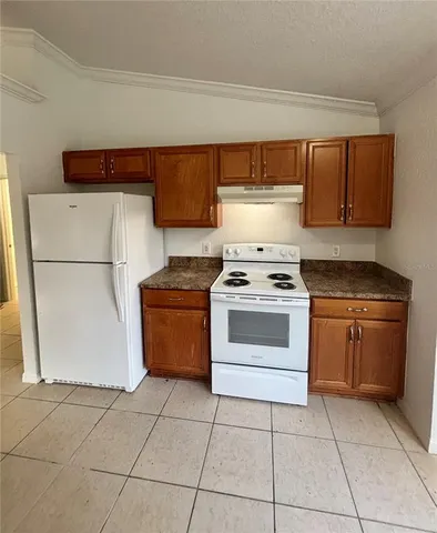 a kitchen with a stove top oven and cabinets
