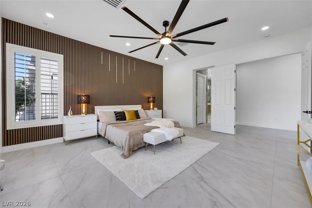 5015 Rivedro Street Las Vegas, NV 89135 - Photo 41 of 91 A tranquil primary bedroom with a spacious layout, featuring a large window, a modern ceiling fan, and elegant recessed lighting.