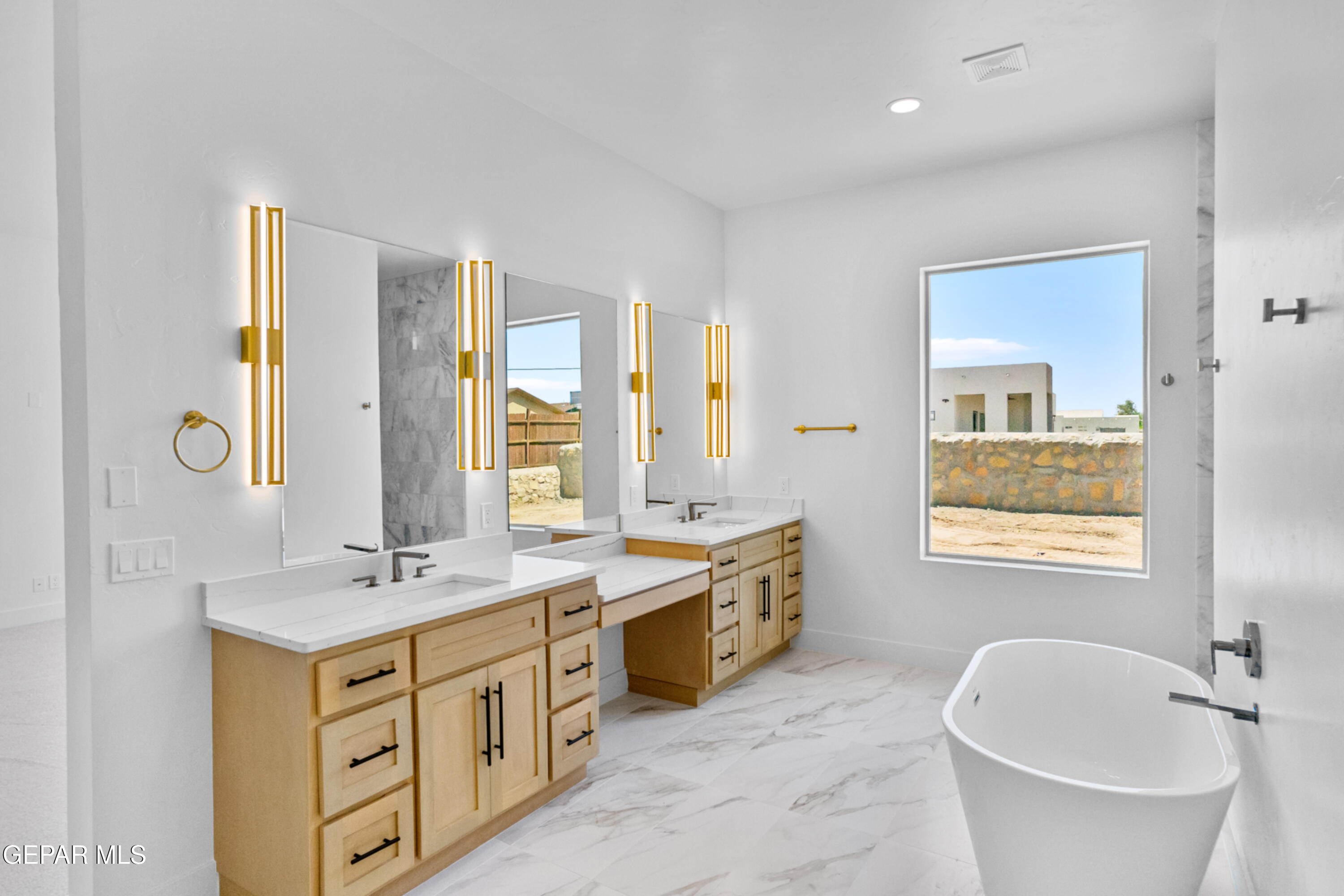 5699 Rio Bonito Circle El Paso, TX 79932 - Photo 16 of 25 a spacious bathroom with a double vanity sink a mirror a bathtub and next to a window