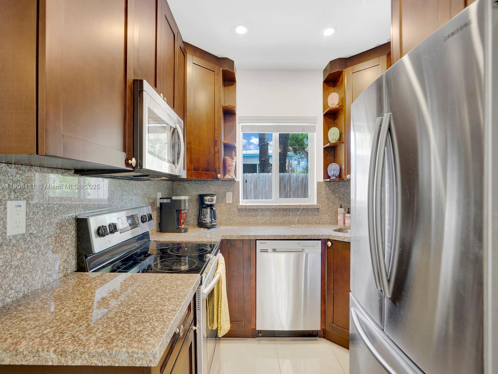 3547 William Avenue Miami, FL 33133 - Photo 11 of 20 a kitchen with stainless steel appliances granite countertop a refrigerator a stove and a sink