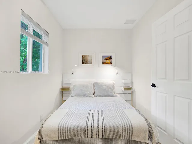 a bedroom with a large bed and a window