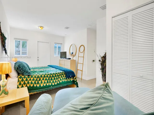 a bedroom with a bed couch and a window