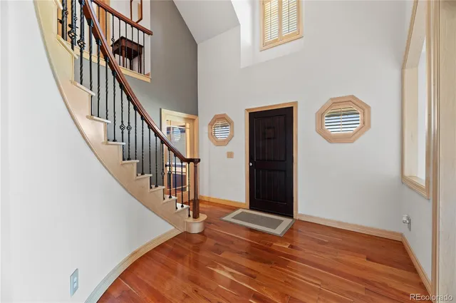a view of staircase with lots of frames on wall and wooden floor