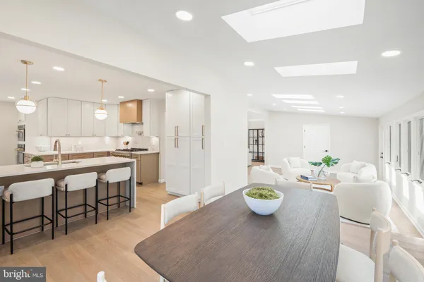 a living room with furniture kitchen view and a chandelier
