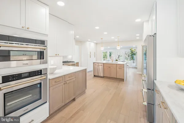 a kitchen with a sink a counter space appliances and cabinets