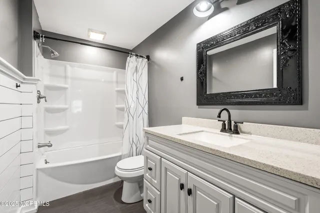 a bathroom with a granite countertop toilet sink and mirror