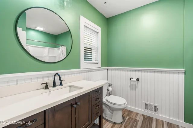 a front view of a house with a garden and trees