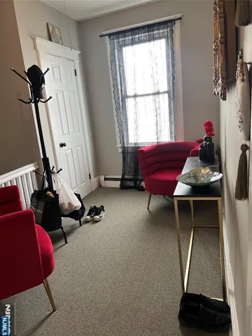 a living room with furniture a air conditioner vent and a window