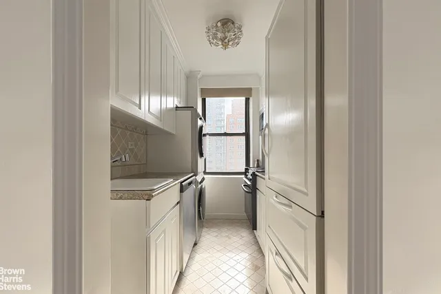 a kitchen with a refrigerator and white cabinets