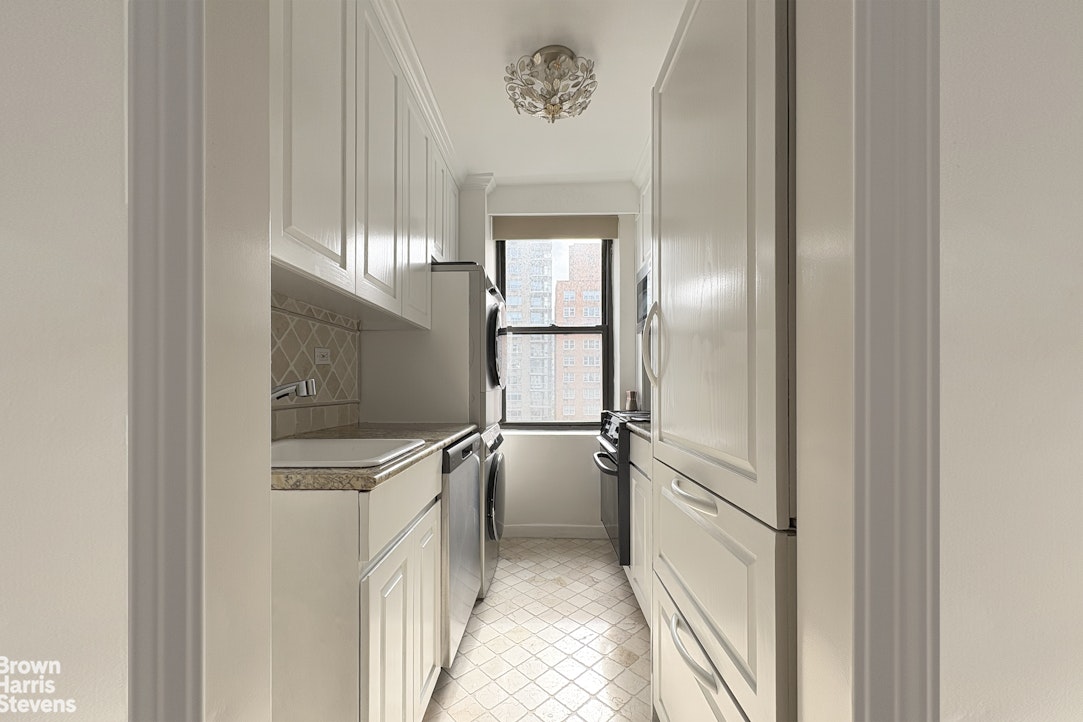 235 East 73rd Street, Unit 8D Manhattan, NY 10021 - Photo 1 of 9 a kitchen with a refrigerator and white cabinets