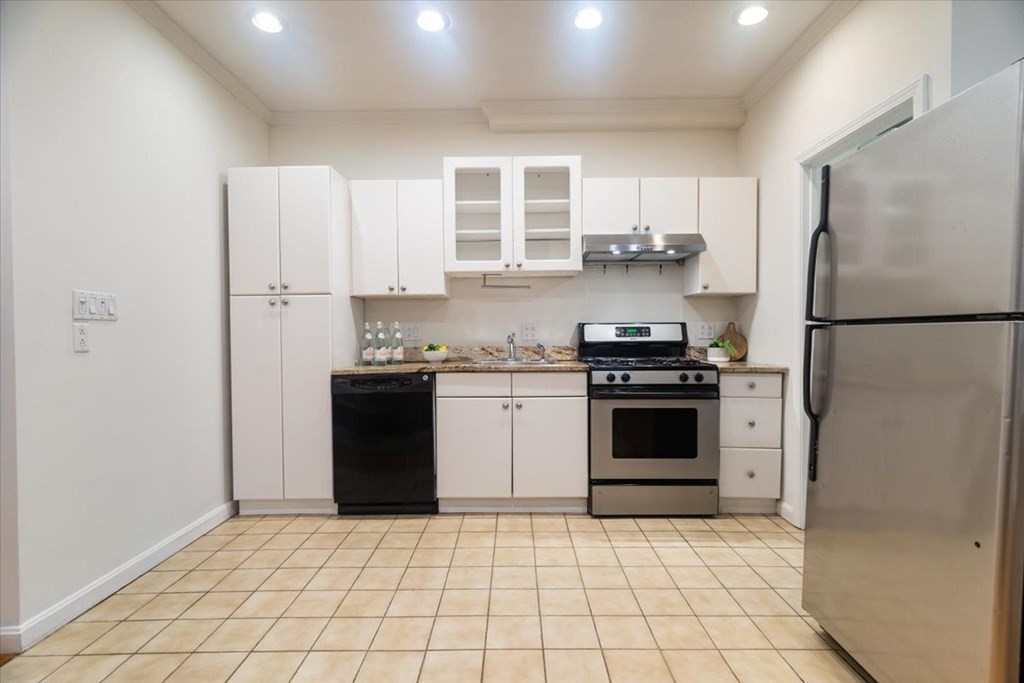 245 West Fifth Street, Unit 2 Boston, MA 02127 - Photo 6 of 34 a kitchen with a refrigerator a stove top oven and cabinets